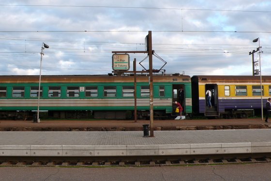 Ein alter Zug am leeren Bahnhof von Riga. Eine Frau steigt aus, eine ein.