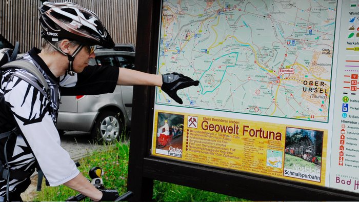 Fahrradfahrer liest Infotafel